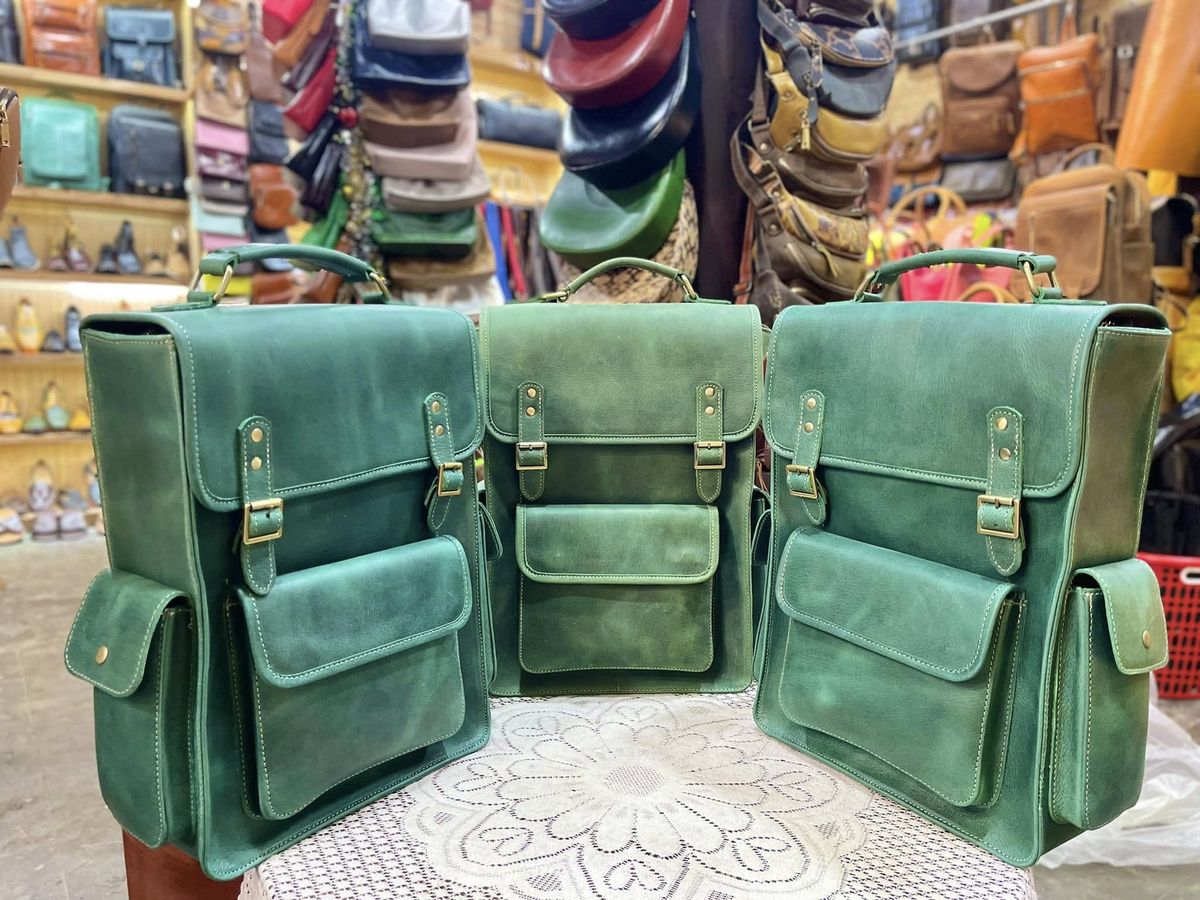 Three green woven leather backpacks at Bison Leather Shop in Hội An