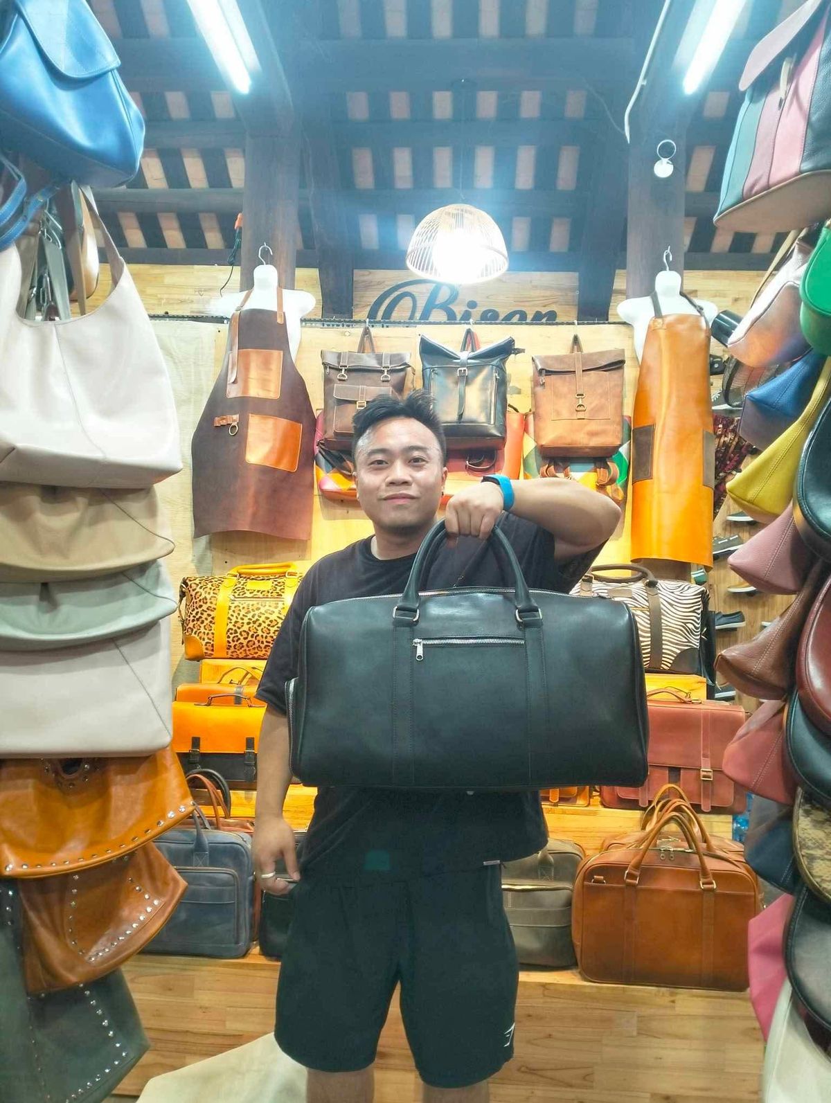Customer holding a black leather weekender bag made at Bison Leather Shop