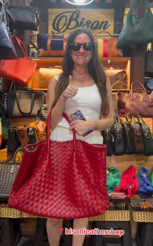 Customer holding a red woven leather tote bag from Bison Leather Shop, Hội An