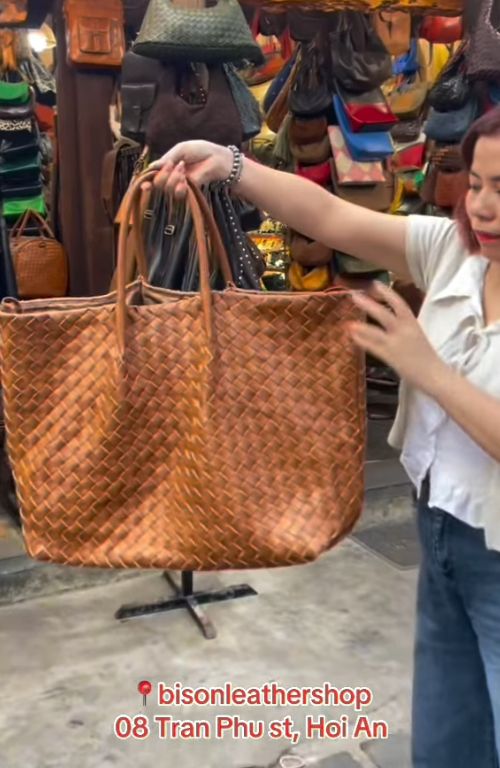 Large tan woven leather tote bag on display at Bison Leather Shop, Hội An